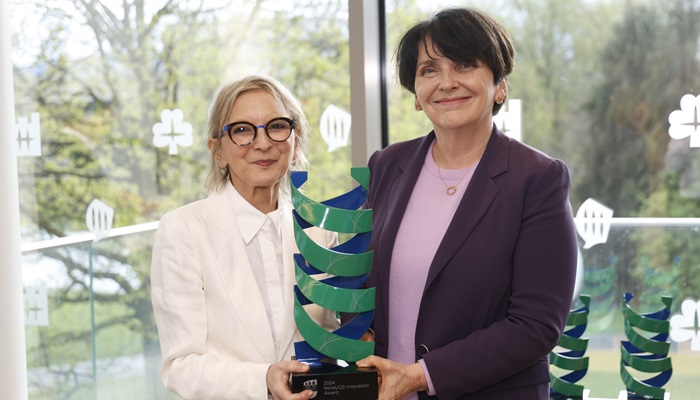 Women smiling with award plaque