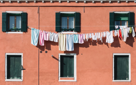 Clothes on a washing line in front of colourful house fassade