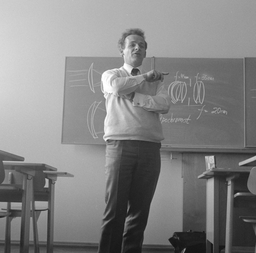 A black and white image of a professor addressing his class