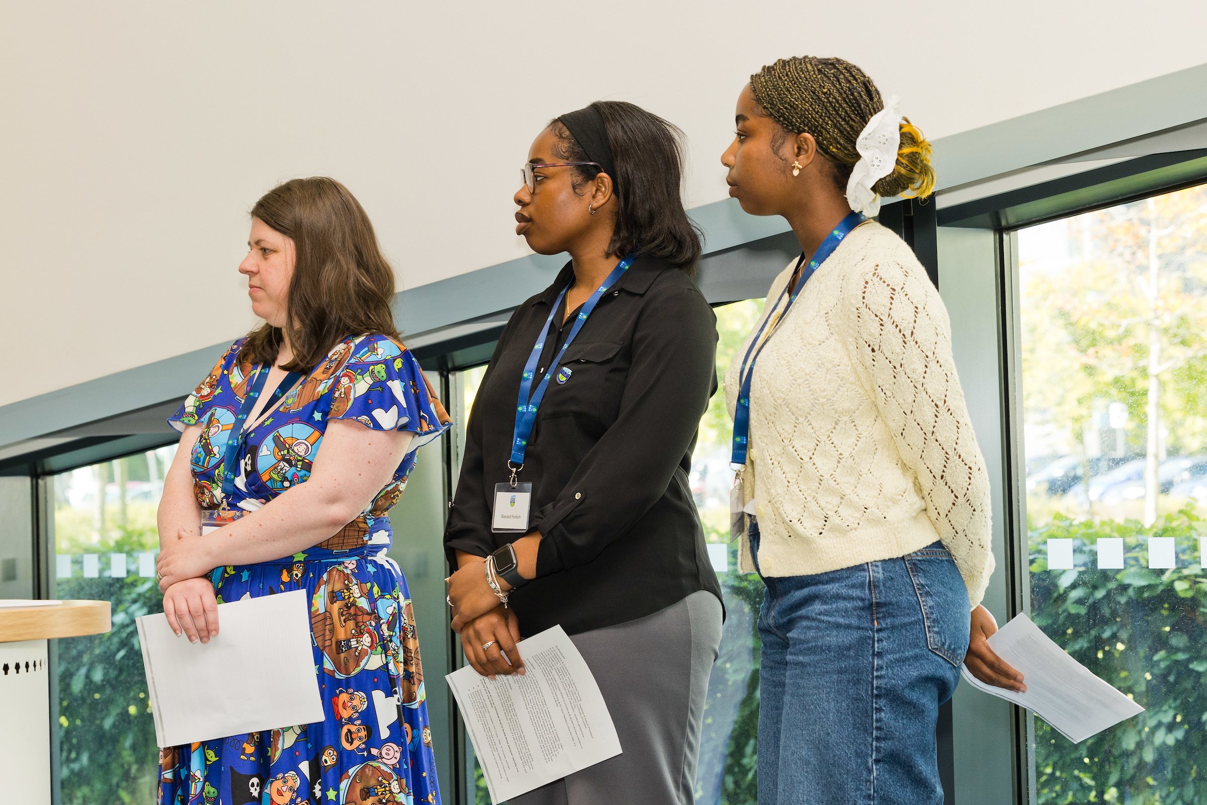 Three UCD students standing at the desk during the 2025 UCD Access Symposium