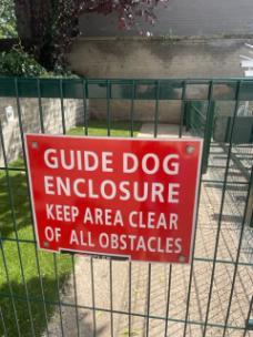 Front gate of guide dog enclosure stating it is for guide dogs