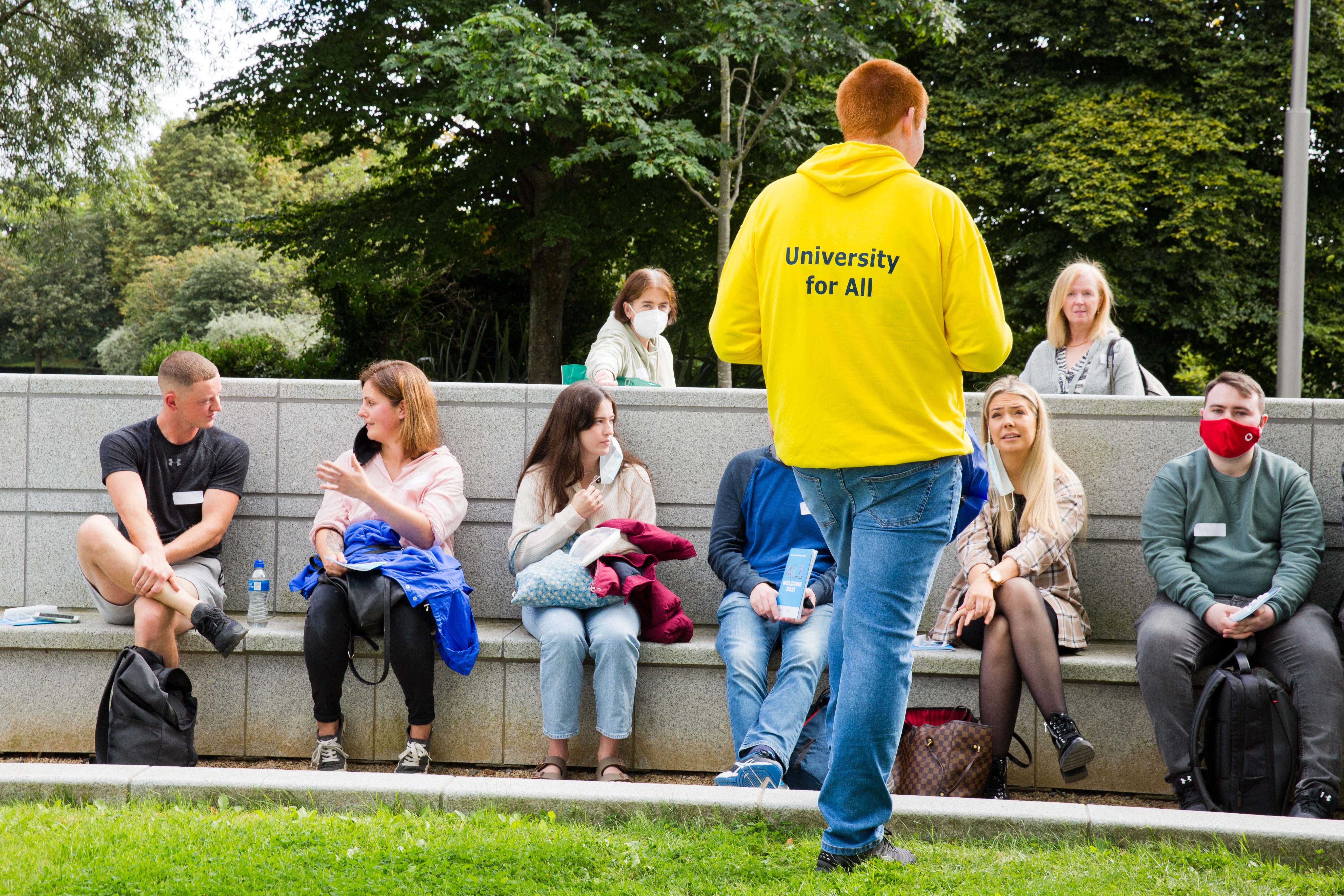 Students sitting chatting outside with a UCD Access Leader
