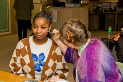 2 people taking part in a facepainting activity at Incluza Palooza