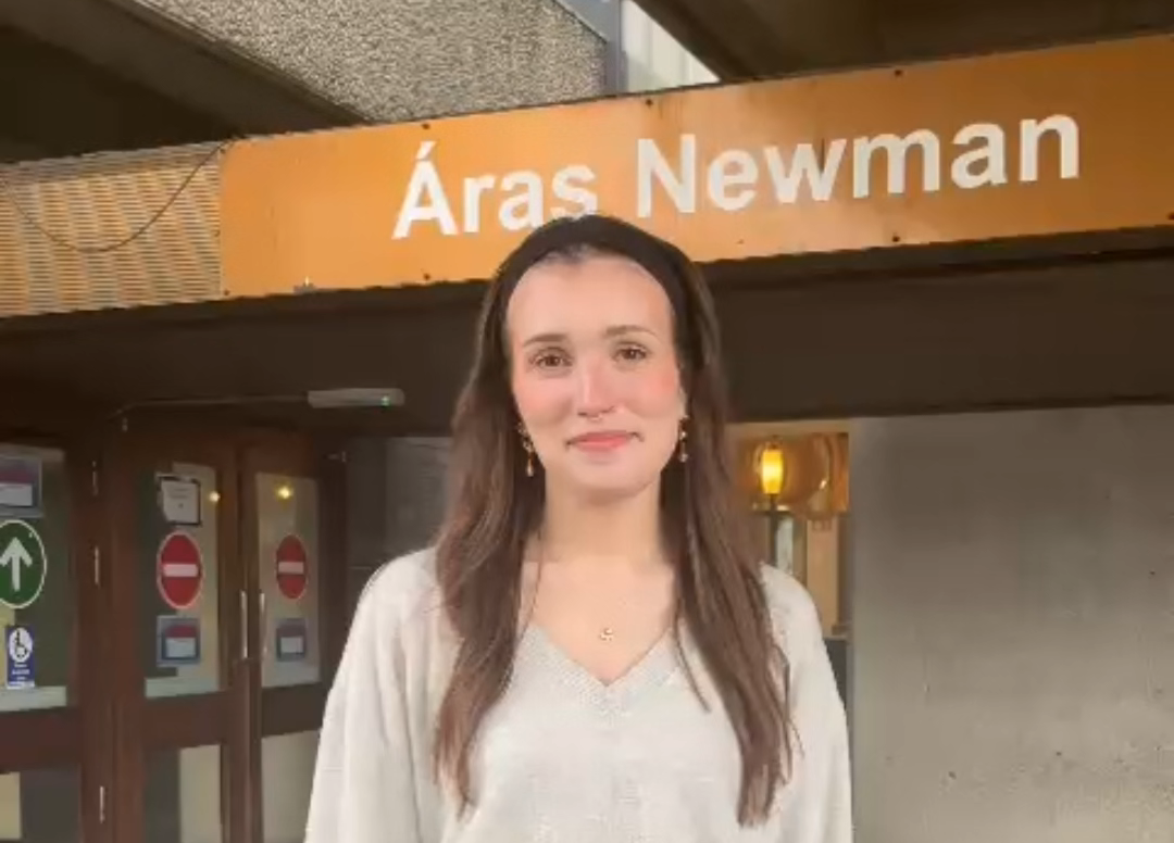 An ALL staff member smiling at front entrance to Newman Building