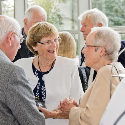 Three older alumni laughing together at their Golden and Diamond Reunion