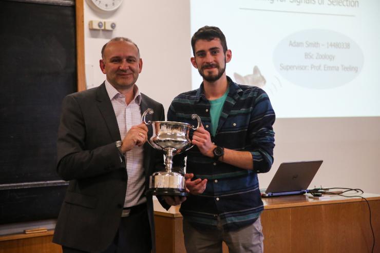 Adam Smith pictured being presented the cup by Prof Jeremy Simpson