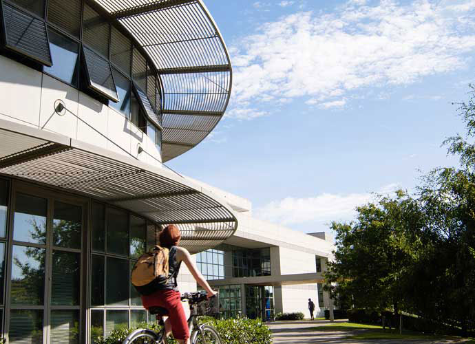 A woman cycling past the conway institute