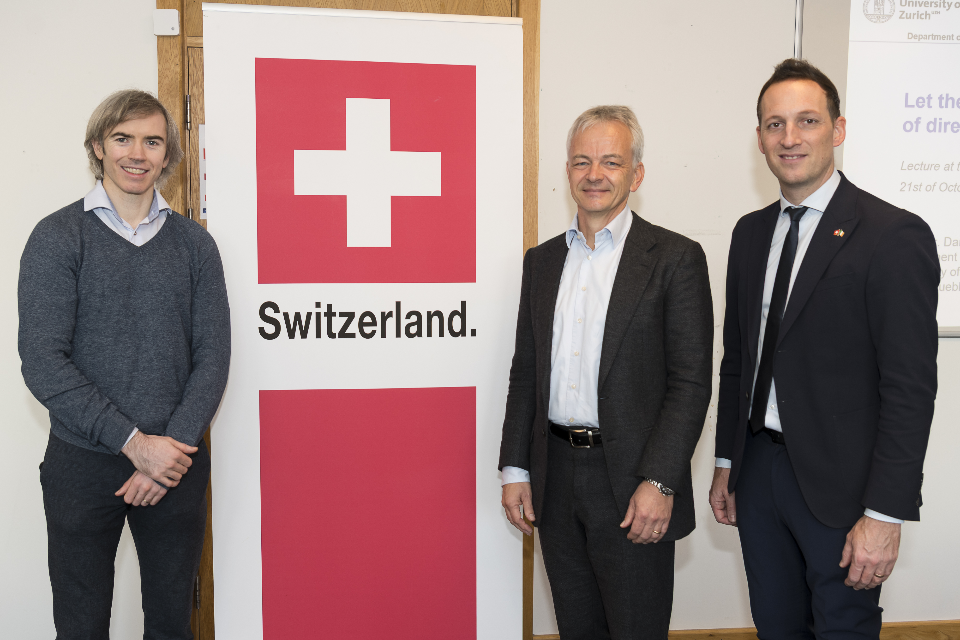 3 people standing by a switzerland banner