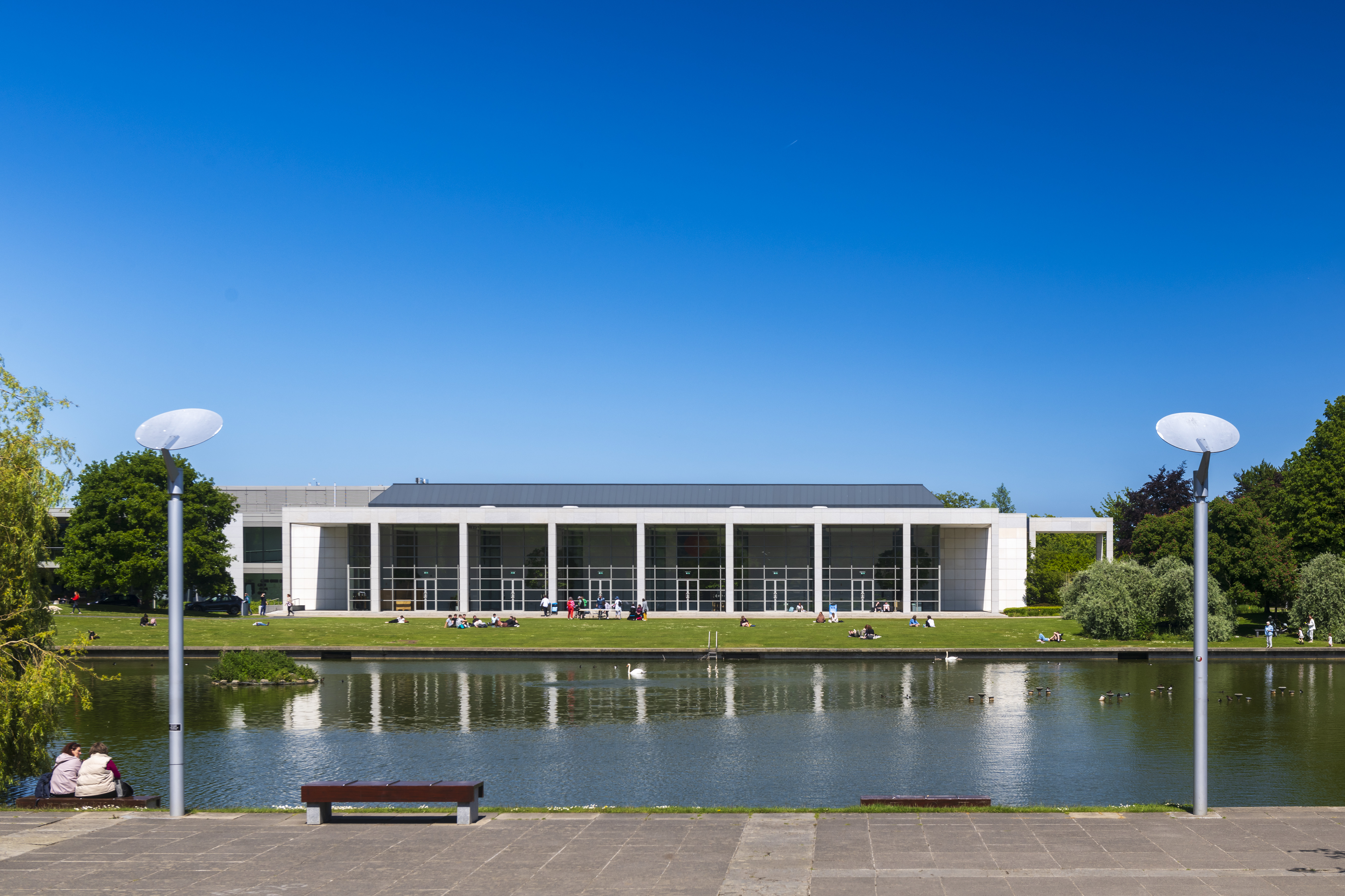 O'Reilly Hall with a calm lake on a sunny day
