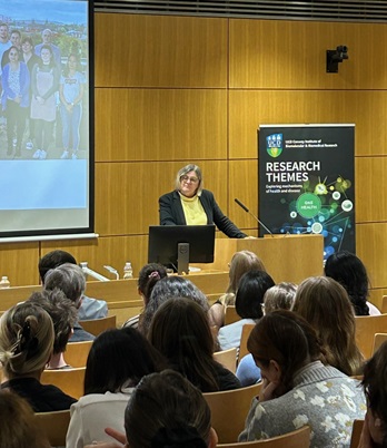 Woman at podium in lecture theatre