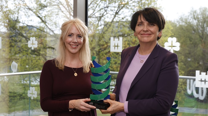 Women smiling with award plaque