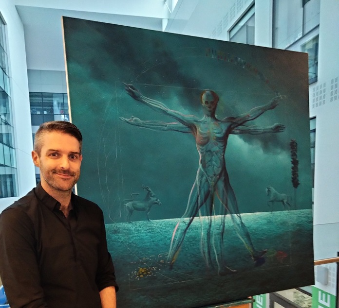 Man pictured beside blue painting