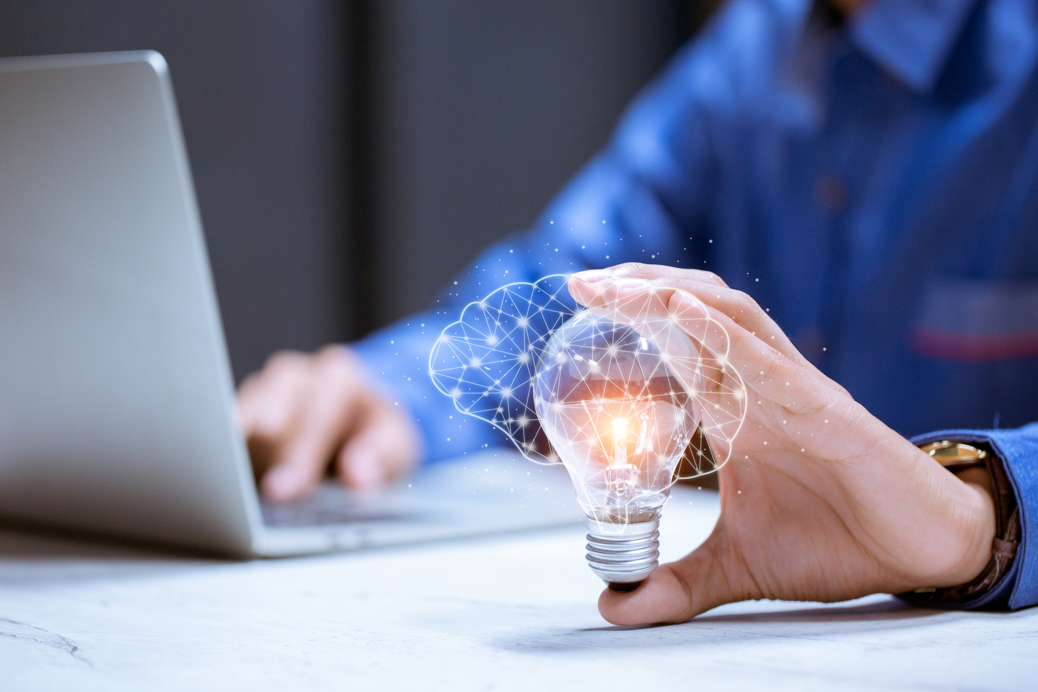 Person on computer with lightbulb in their hand