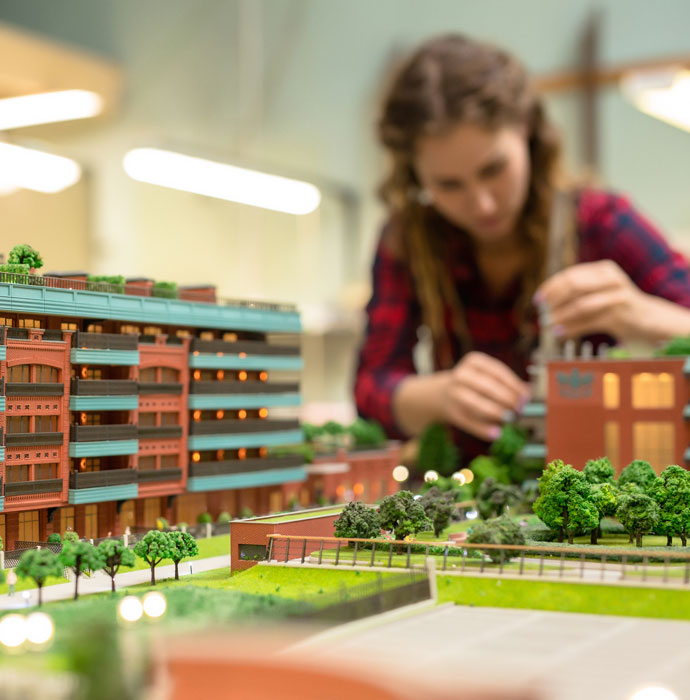 An architect standing behind a housing model