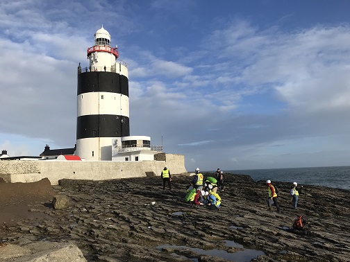 Students on rock shore under Hook Head lighthouse Wexford