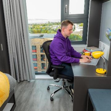 A student working at a desk in UCD accommodation