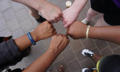 Hands of people from different races first bumping each other