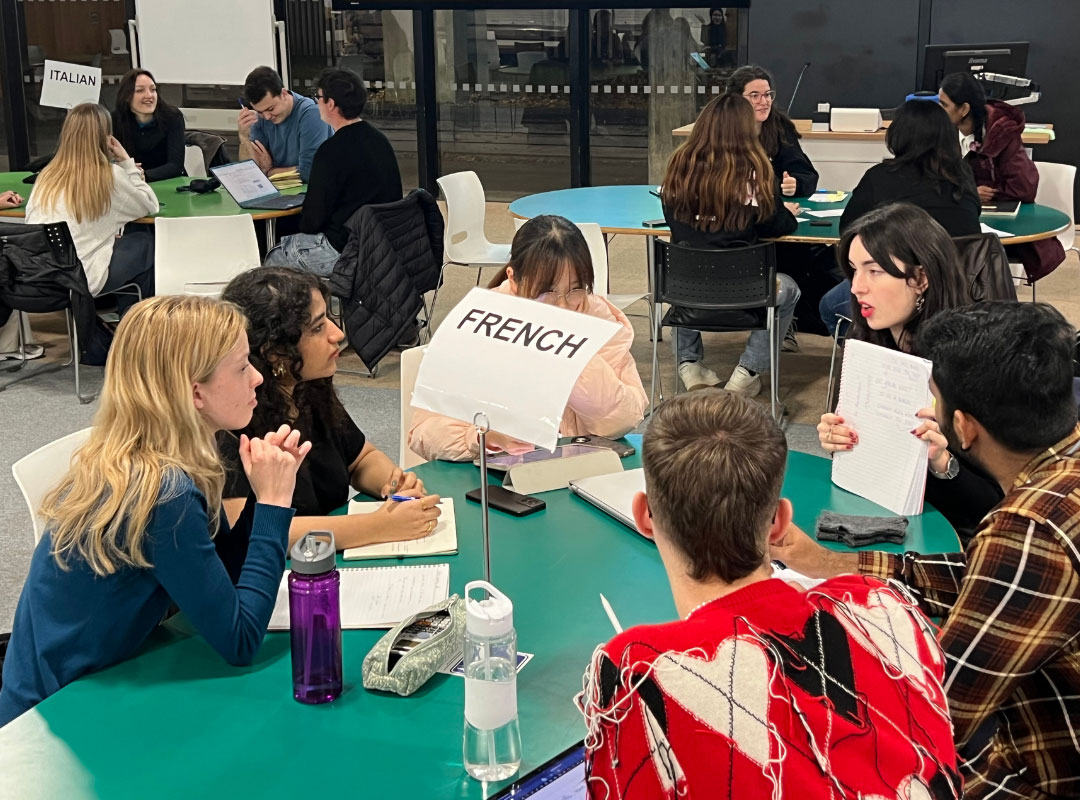 Students seated at a table with a sign that says 'French'.