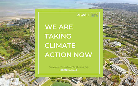Aerial view of University College Dublin’s campus with a green overlay in the center that reads “We are taking climate action now.”