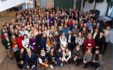 A large group of people smiling to camera.