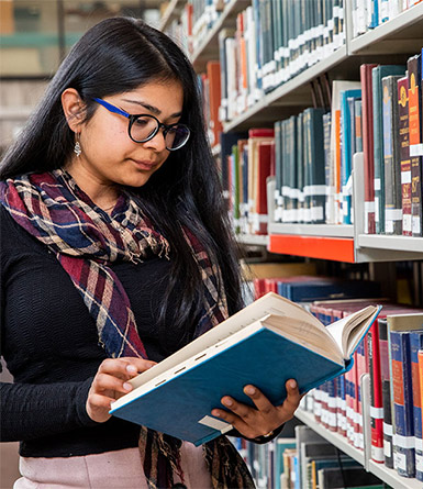 Young woman with black hair reading a book.