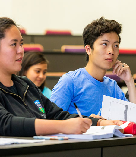 Students listen intently in a lecture hall.