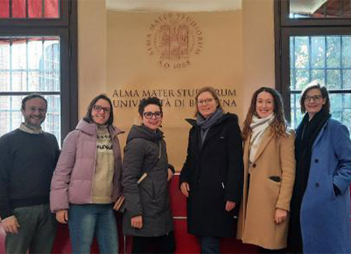 A group of people stand together, posing for the camera and smiling.