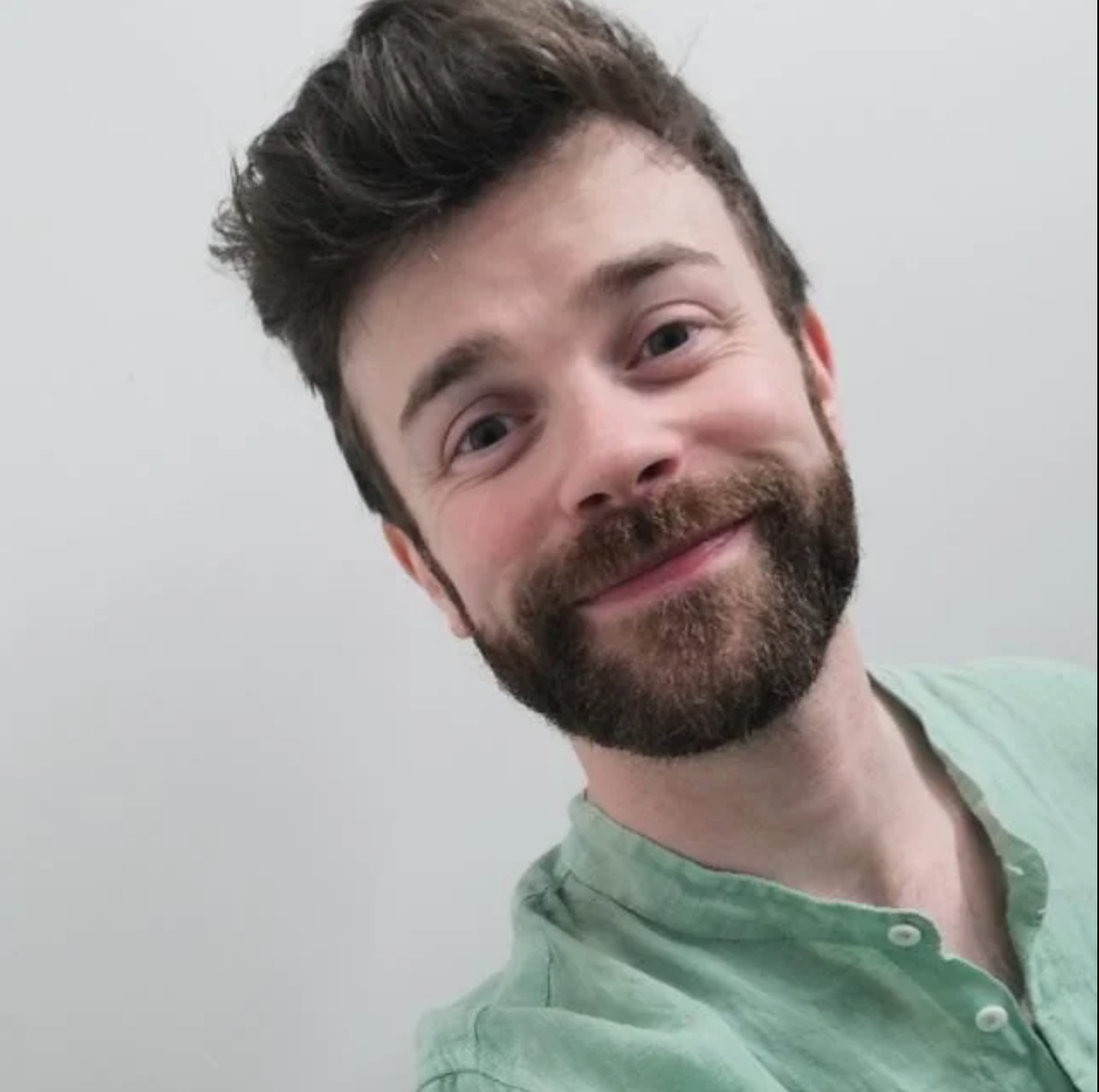 A head shot of Eoin Mc Evoy smiling and wearing a green shirt