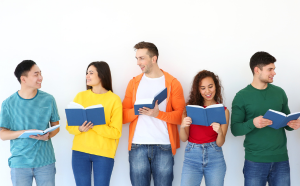 Students in colourful jumpers with books in their hands