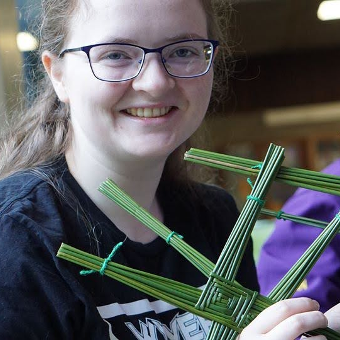 A portrait of a girl making St.Brigid's crosses