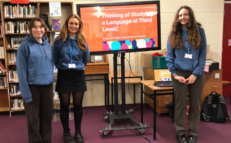 Three students in front of a presentation