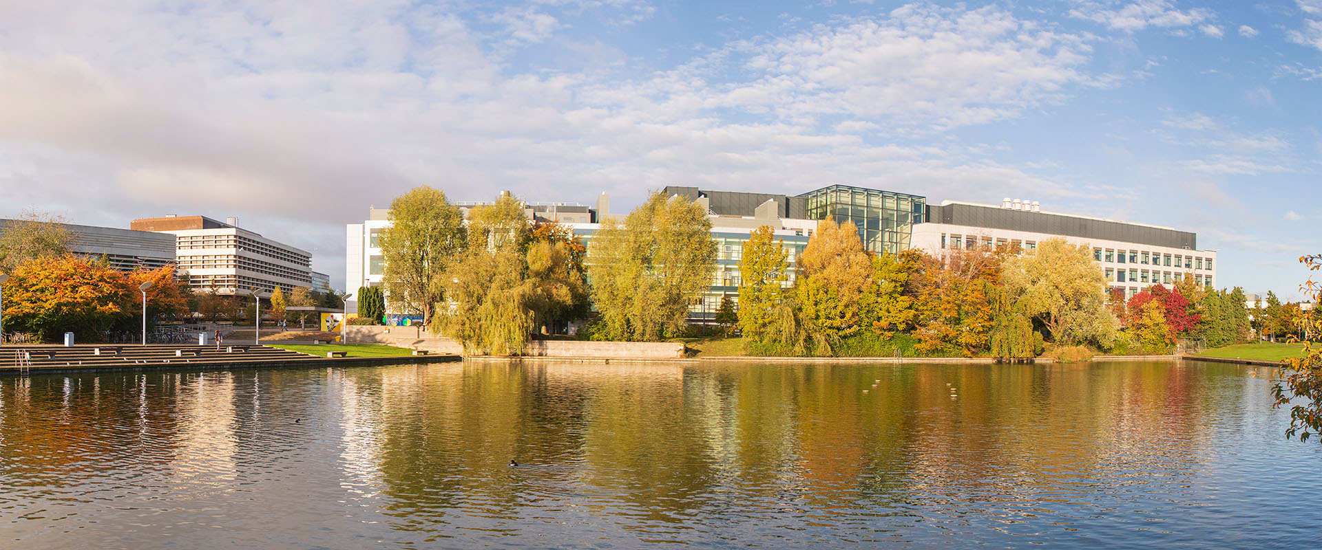 Belfield campus autumn sunshine, Science Centre with autumn foliae and the lake in the foreground