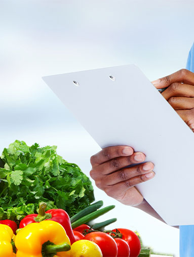 Woman holds a clipboard over vegetables and fruits.