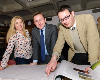 Pictured: Minister Brian Hayes views plans of the Hill of Ward excavation site while on a visit to University College Dublin. Dr Stephen Davis (right), UCD School of Archaeology, who will lead the excavation and Ms Cathríona Moore (left), UCD graduate, who will collaborate on the project. 