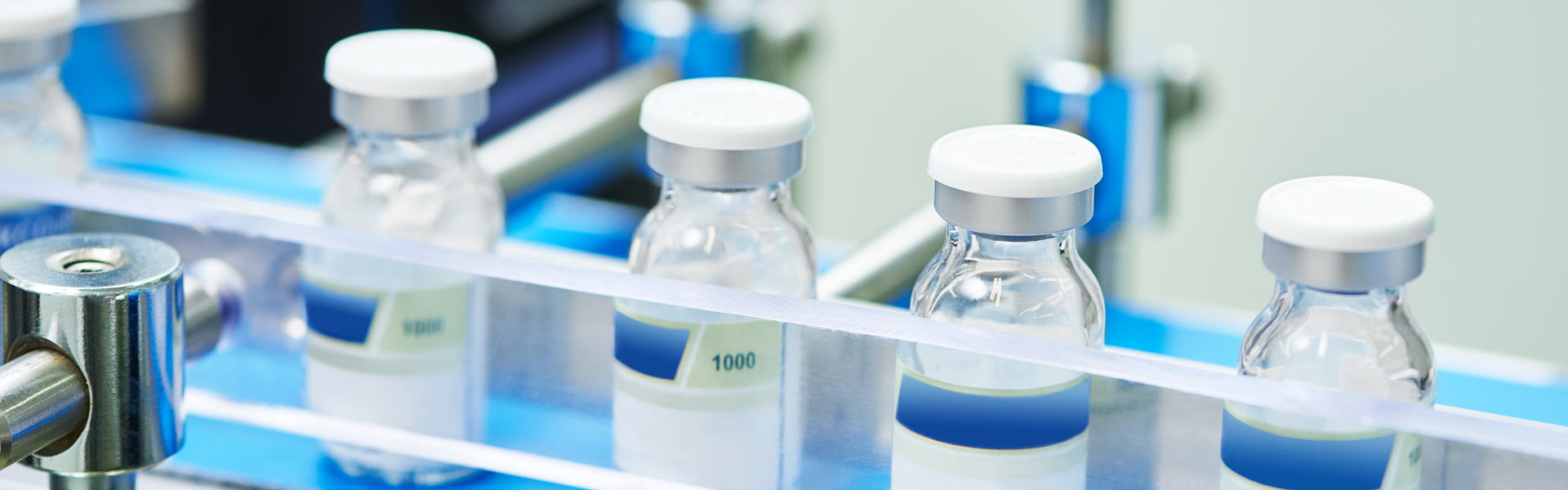 Small glass bottles used for medicine in a factory.