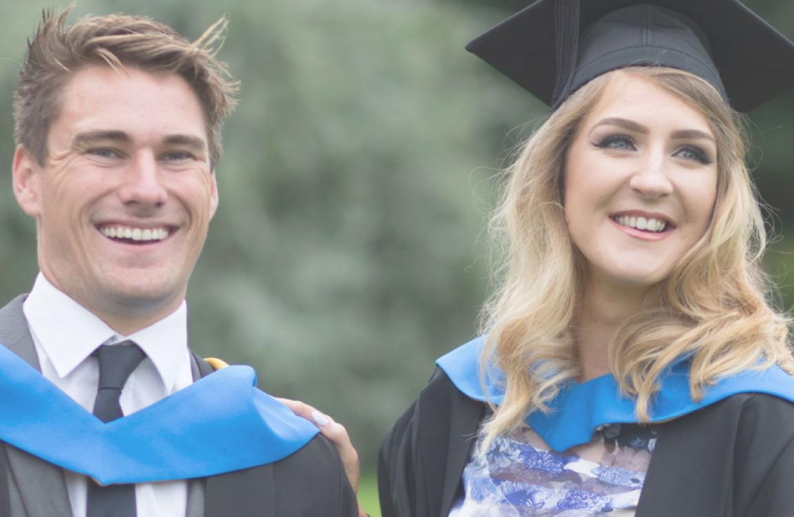 Two students in graduation gowns