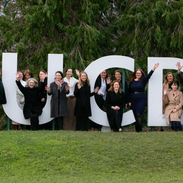 Group of people standing at a large UCD sign