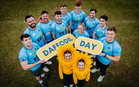 Group of rugby players with two children in yellow daffodil headwear