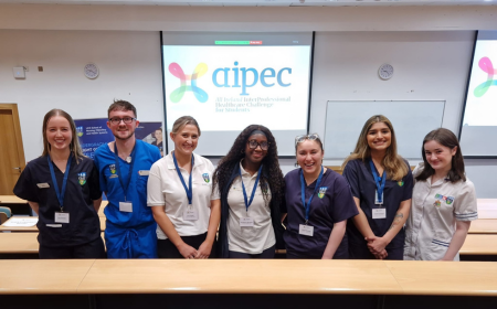 A group of healthcare students standing in front of a projector screen