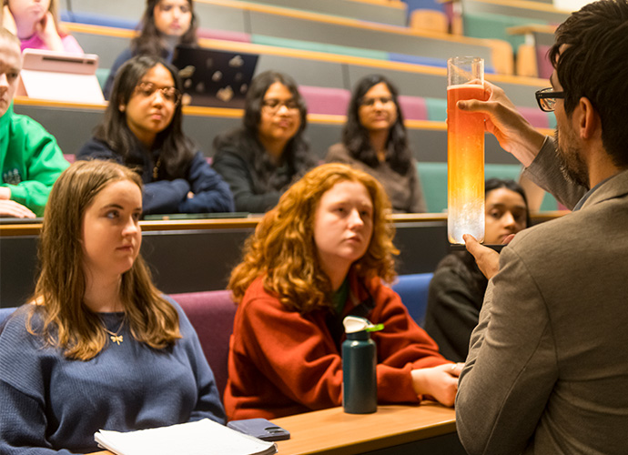 Students in a theatre doing a physics demonstration