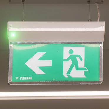 Emergency running green man with arrow to exit