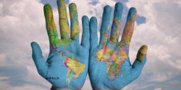 Image of two hands with world map painted on them