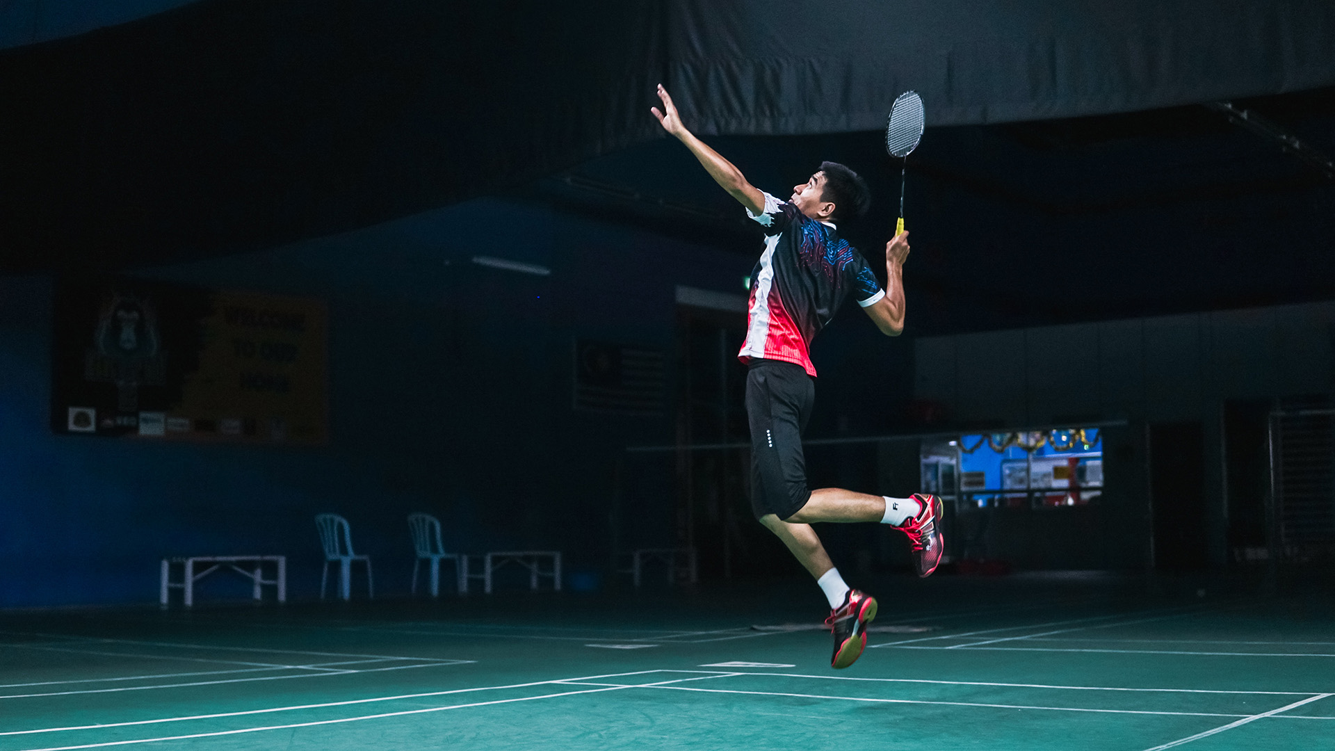 A badminton player jumping for a shot