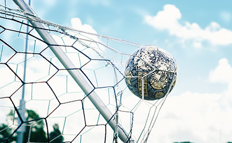 A football hitting the back of the net
