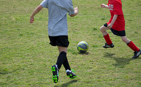 Kids playing soccer on grass