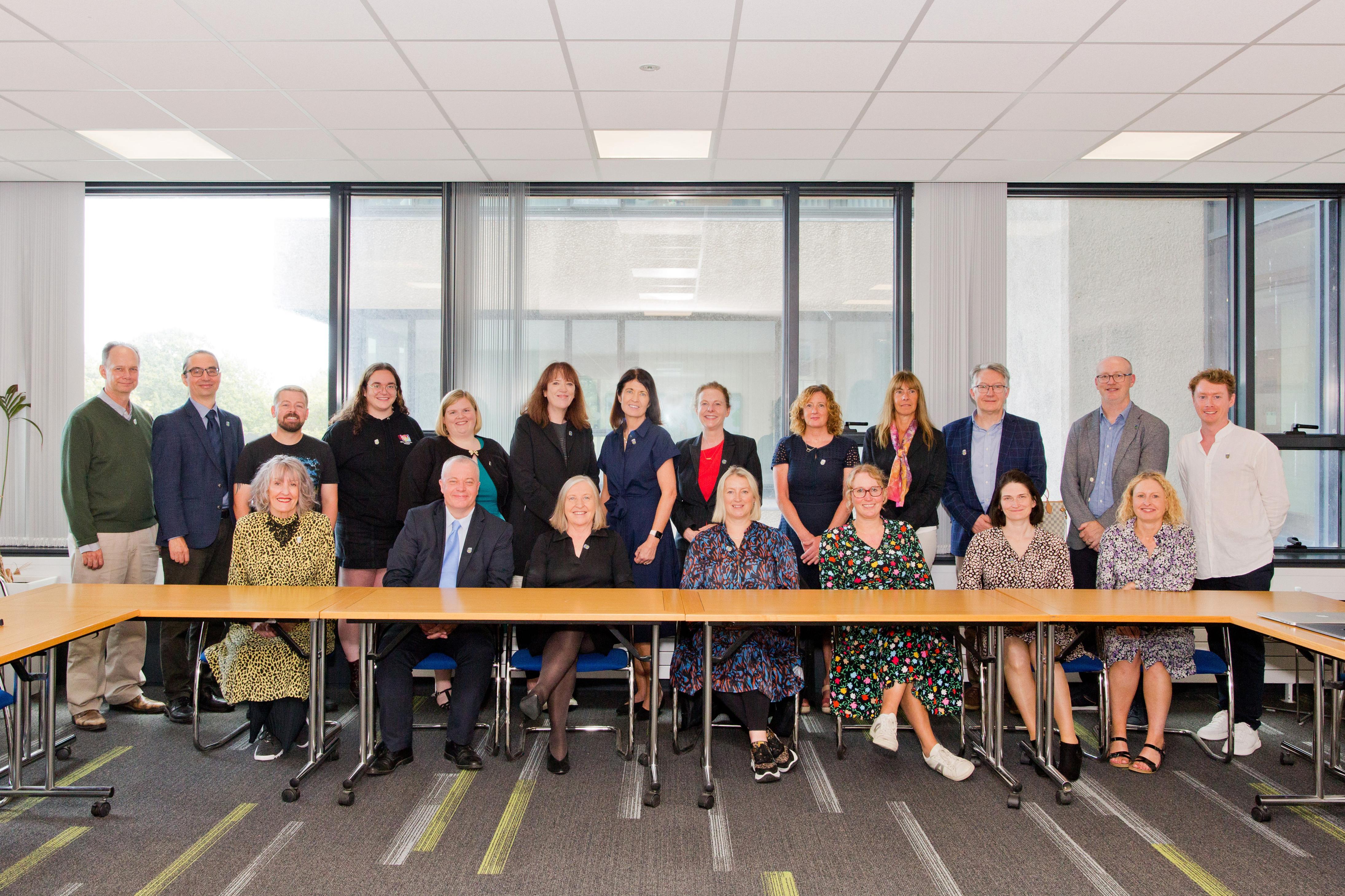 Picture of the members of the Widening Participation Committee sitting and standing