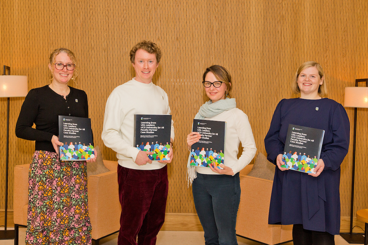 photograph of 4 people smiling with each person holding a book