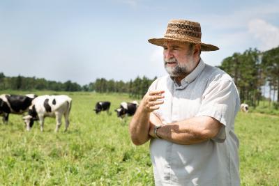 Michael Riordan standing in field with cows