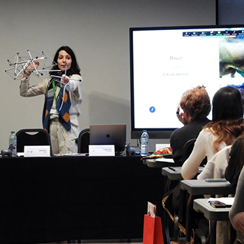 Maria Gomez Sanchez giving a presentation in front of a group of people sitting at desks