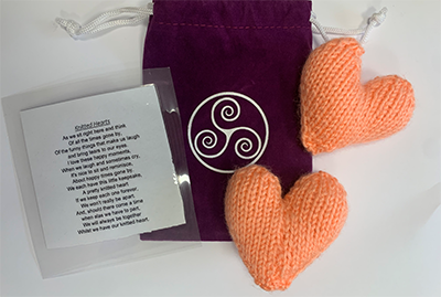 Photo of two knitted hearts with a small bag and a poem